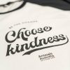 'Choose kindness' logo on white shirt with black sleeves, shoulders and neck